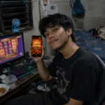 ผู้ใช้งาน TUNDER24HR ถือมือถือแสดง Mega Win 18,900 พร้อมเล่นสล็อตบนคอมพิวเตอร์
